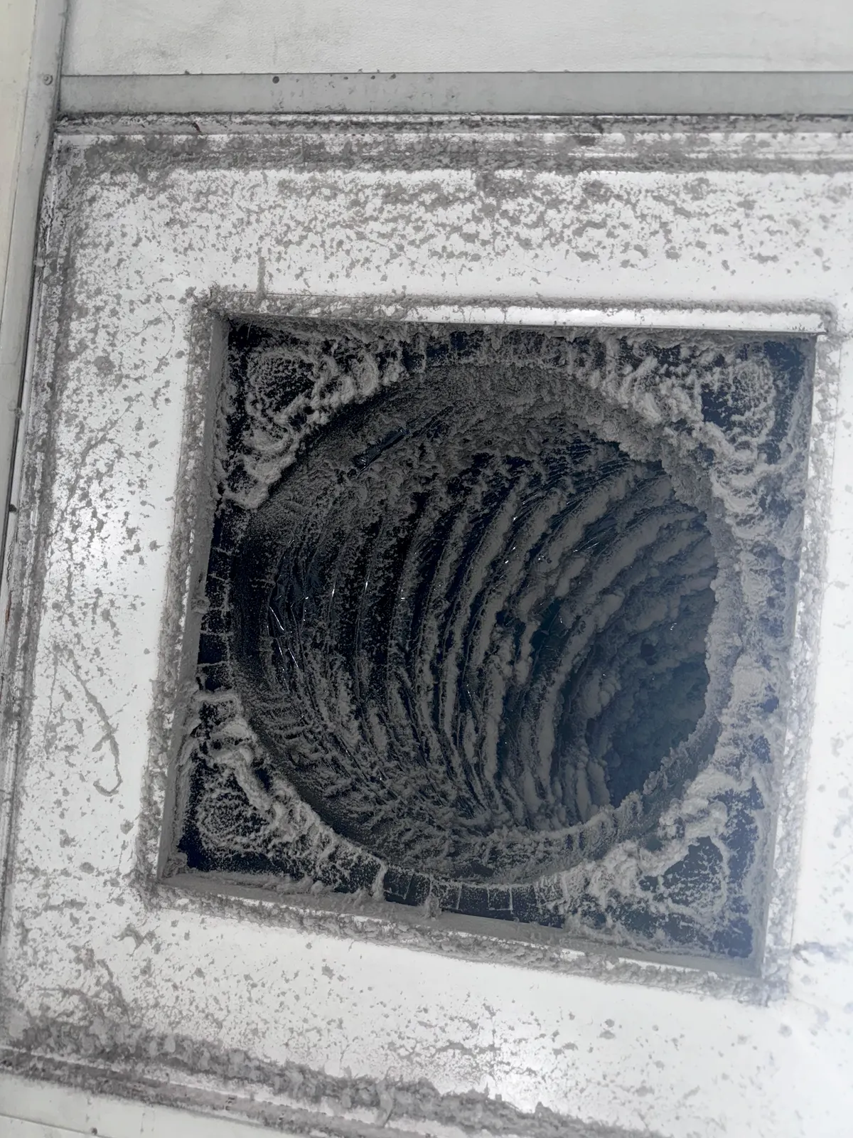 Heavy dust layer inside hotel supply duct before cleaning