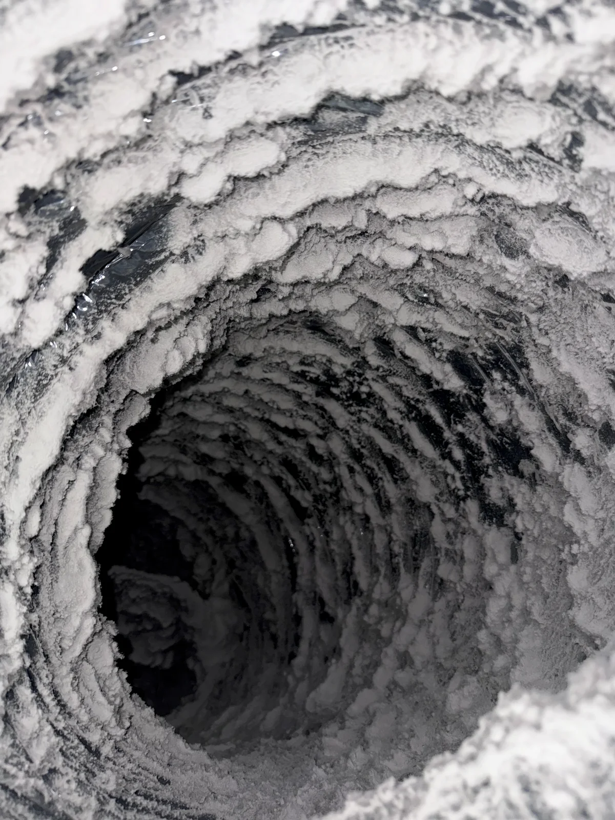 Concentric rings of compacted dust inside a round duct branch at Courtyard by Marriott Portland