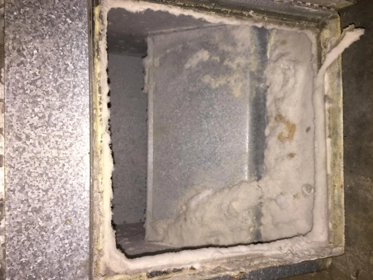 Duct interior before cleaning — heavy dust and debris buildup