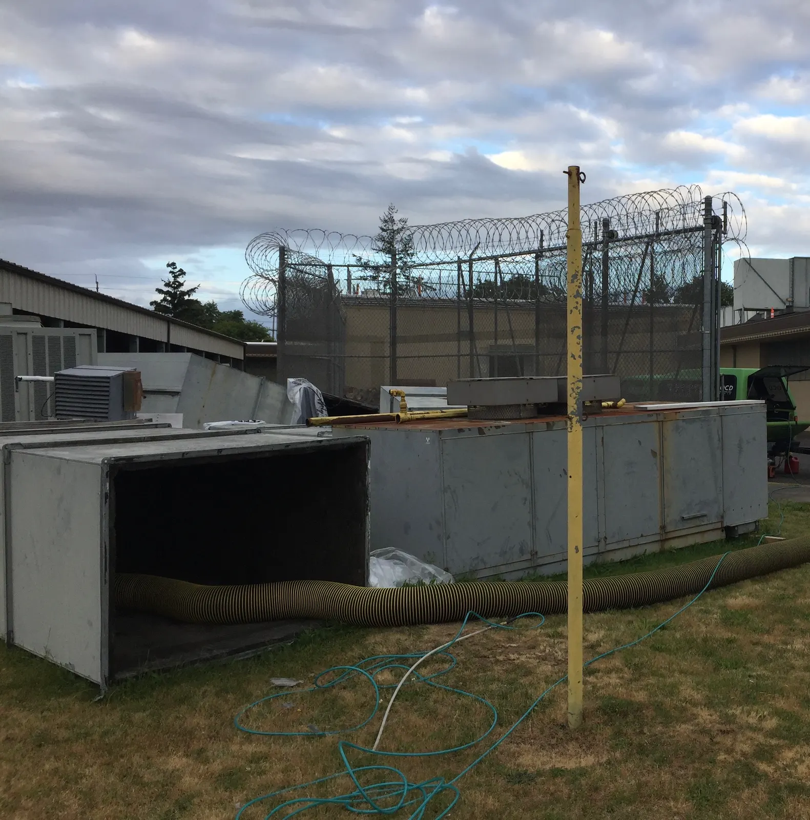Large commercial duct sections staged outdoors with vacuum hose during Oregon State Penitentiary cleaning project