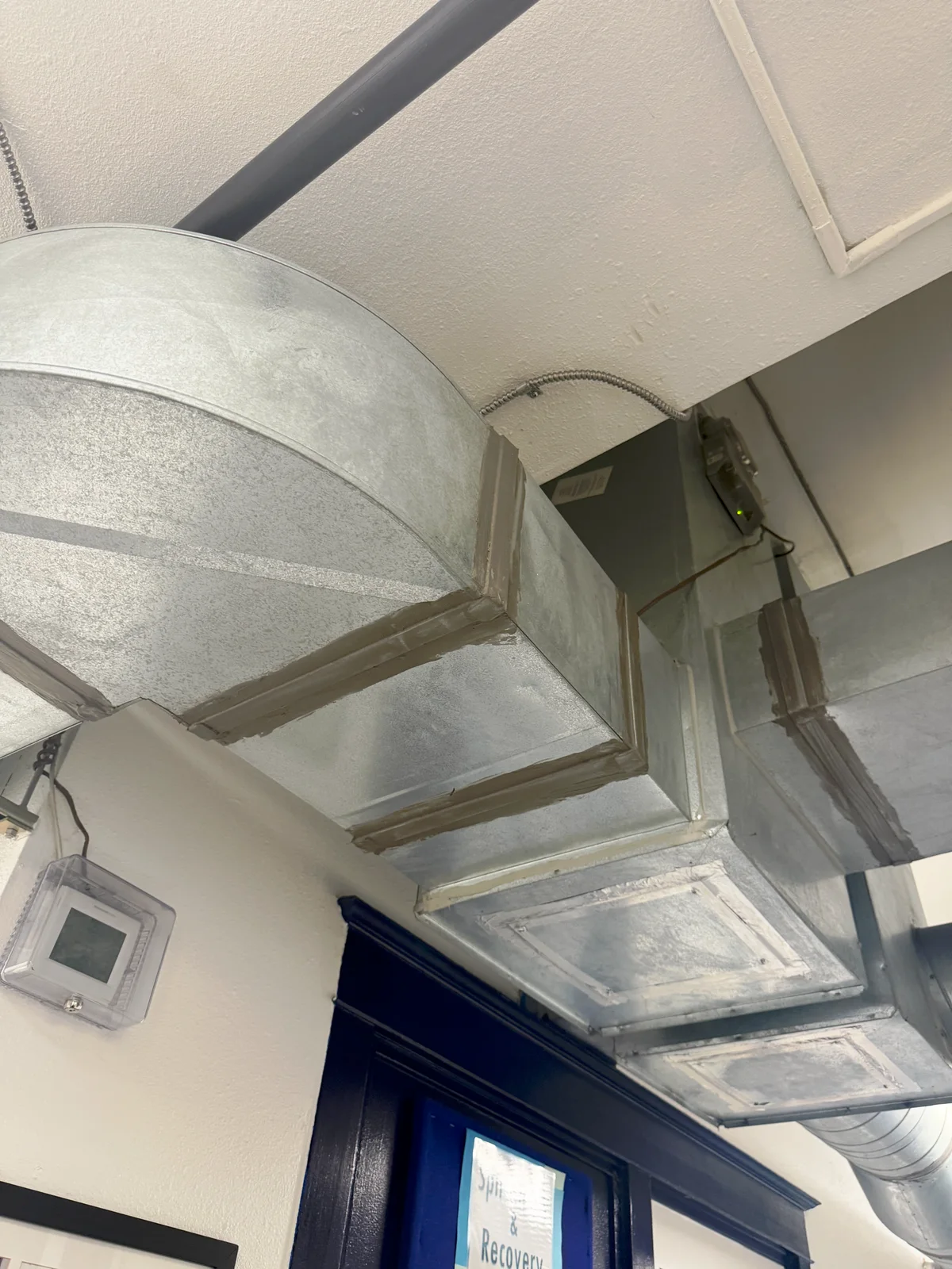 Galvanized supply and return ductwork mounted at ceiling inside VOA Oregon Men's Residential Center